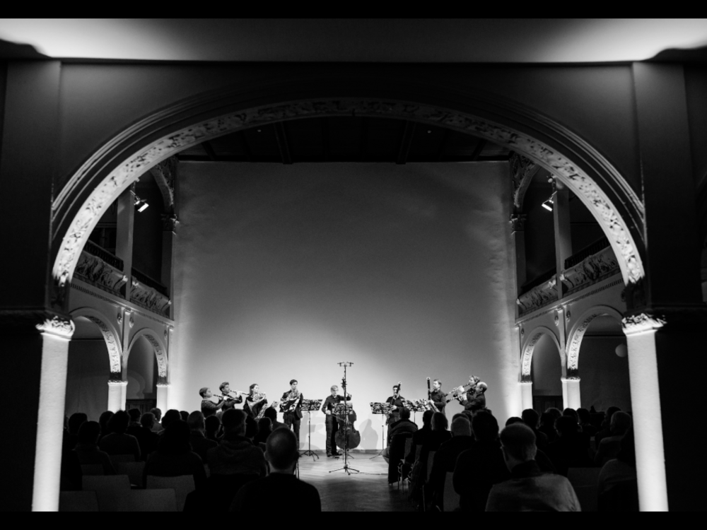 Eine Gruppe Musiker:innen spielt in einem großen Gewölbe