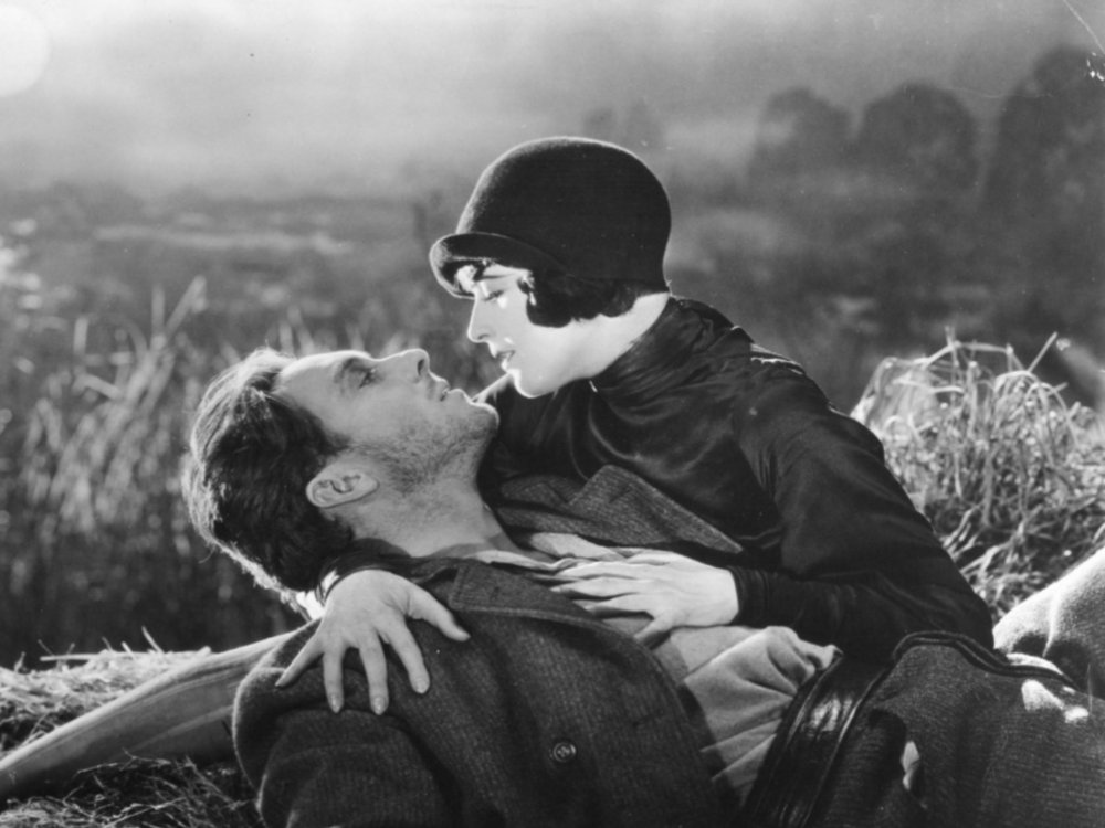Ein Mann liegt am Boden und wird gehalten von einer Frau mit 1920er Bubikopf